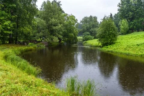 A small river flows among meadows and groves Stock Photos
