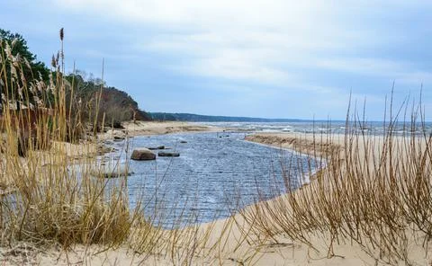 A small river flows into the Gulf of Riga in the Baltic Sea in winter Stock Photos