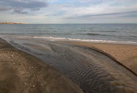 A small river that flows into the sea. Stock Photos