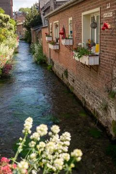 Small river flows throughout beautiful French village Veules-les-Roses, old h Stock Photos