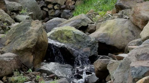 Small river with large rocks on the slopes of the mountain Stock Footage 280378613