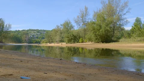 A small river or pond with fish near forest with hotel buildings or houses 動画素材 114907469