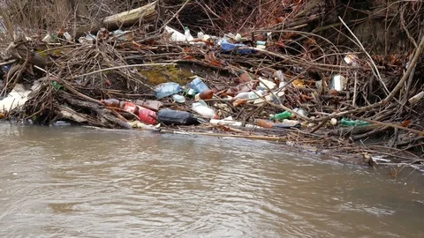 Small river polluted with human trash Stock Footage 121881652