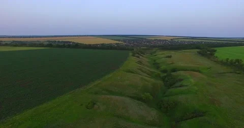 Small river in the prairie, cultivated fields, roads, the evening sky 스톡 동영상 64414099