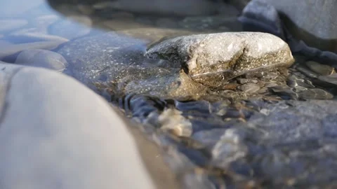 Small river with rocks. Water in a mountain stream flows around stones. Flowing Stock Footage 146072786