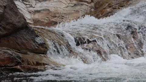 Small river with rocks. Water in a mountain stream flows around stones. Flowing Stock Footage 312110928