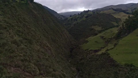 A small river running through the hills covered in trees in the Andes Stock Footage 169896397