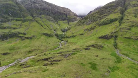 Small river running through the mountains in the Scottish Highlands Stock Footage 311574515