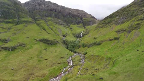 Small river running through the mountains in the Scottish Highlands Stock Footage 311574737