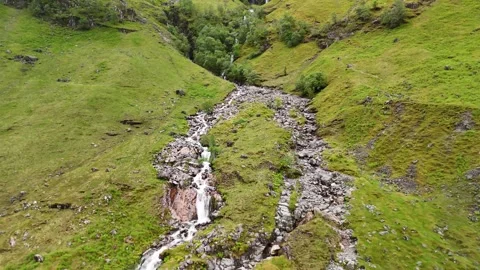 Small river running through the mountains in the Scottish Highlands Stock Footage 311574874