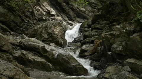 Small river streaming over and between rocks Stock Footage 56162773