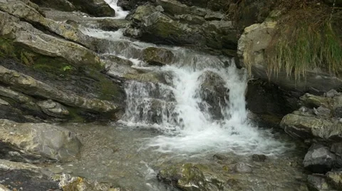 Small river streaming over and between rocks Stock Footage 56163111