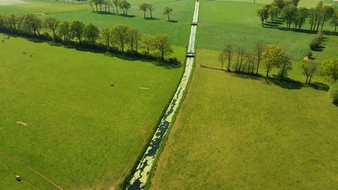 Small river streaming trough typical green Dutch landscape 動画素材 111664050