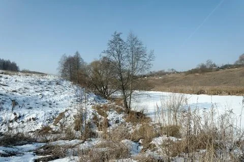 A small river under the ice on a clear day Stock Photos