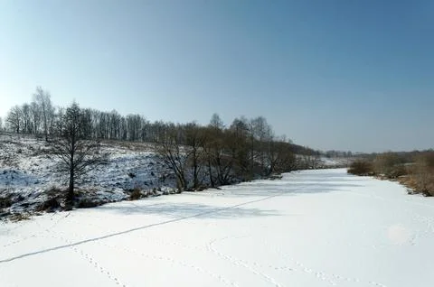 A small river under the ice on a clear day Stock Photos