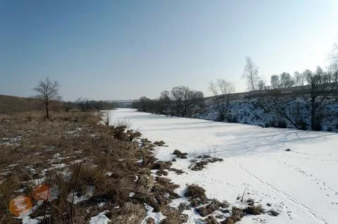 A small river under the ice on a clear day Stock Photos