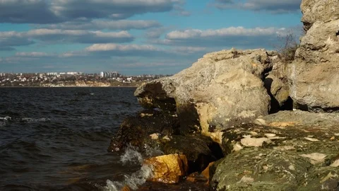 Small river waves crash on wet colorful stone rock beach in wonderful cloudy Stock Footage 107332194