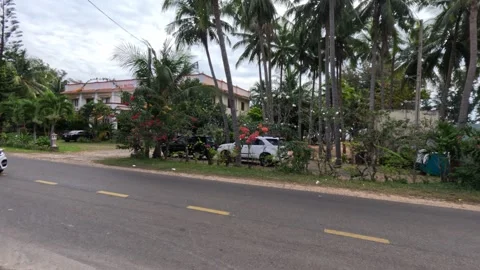 Small road in a quiet resort area in Vietnam. Phan Thiet. Cars are passing by Stock-Footage 242902848