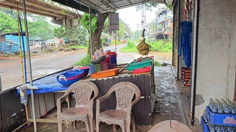 A small roadside shop in India with a few plastic chairs and a table Stock Footage 315616778