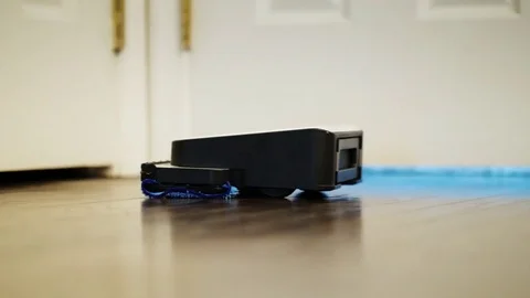 A small robot washes the floor in the kitchen. Wipe the floor with a damp cloth Stock Footage 81769762