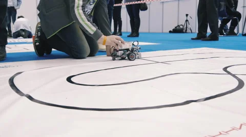 Small robots drive around in a scientific exhibition Stock Footage 61541686