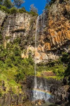 Small rock waterfall creating rainbow rainbow in the rocks below Stock Photos