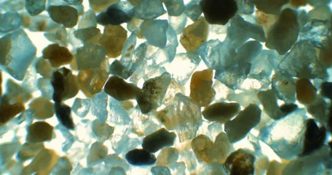 Small rocks under a microscope. Extreme close up of sand sample under scope lens Stockbeeldmateriaal 199347809