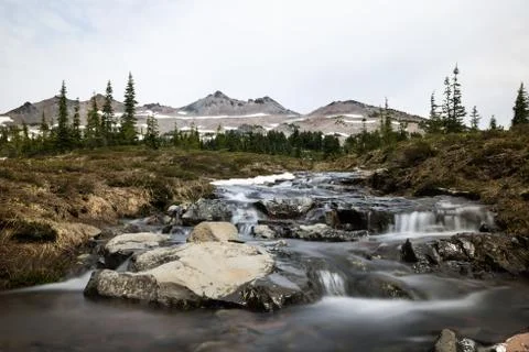 Small rocky stream under distant alpine peaks of Washignton Stock Photos