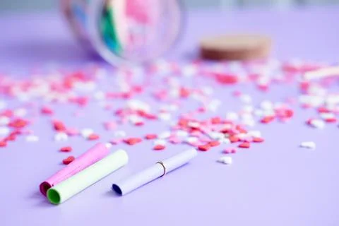 Small roll papers and a jar on a purple background. Jar with wishes for Valen Stock Photos