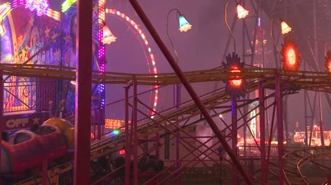 A small roller coaster at an amusement park, carnival or state fair at night. Stock Footage 41984523