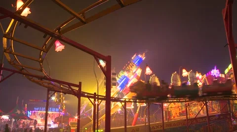 A small roller coaster at an amusement park, carnival or state fair at night. Stock Footage 41984783