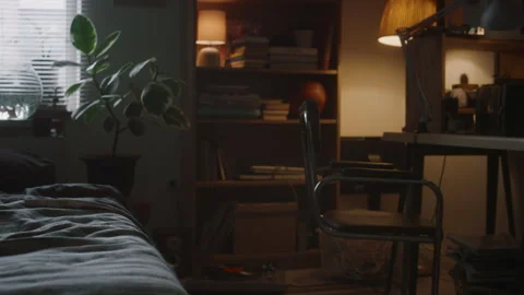 Small Room with Bed, Book Rack and Messy Table in Dim Light Video stock 290860506