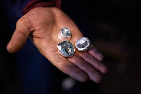 Small round bars of silver lie in the palm of your hand. Stock Photos