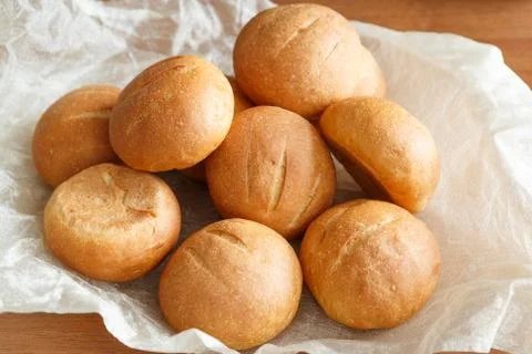 Small round buns for Breakfast on a lighter background fabric on a wooden tab Stock Photos