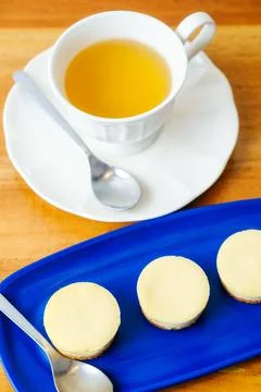 Small round cheesecakes served with a cup of tea Stock Photos