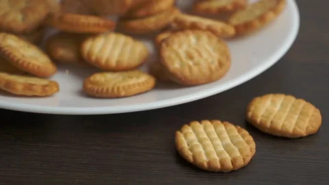 Small round dry cookies falling down on white plate Stock-Footage 152829863