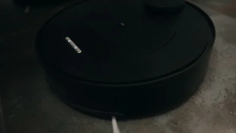 Small round modern programmable vacuum cleaner at work Stock Footage 171919891