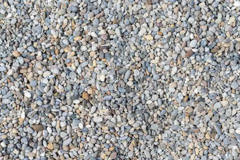 Small round pebbles creating a natural pattern on outdoor ground Stock Photos