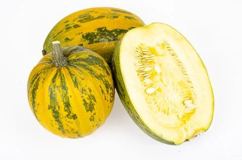 Small round pumpkin cut in half on white background. Studio Photo. Stock Photos