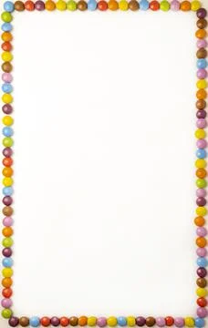 Small round rectangular candies laid out on the edge of the frame on a white Stock Photos