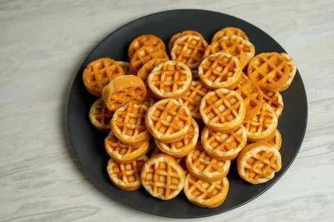 Small round soft waffles layered on gray plates Stock Photos