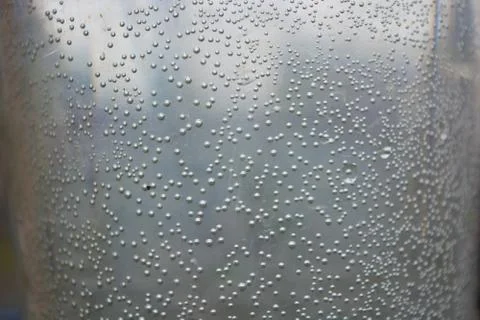 Small, round, spherical bubbles covered the surface of a container of water. Stock Photos