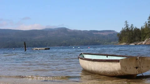 Small Row Boat On A Beach With Mountains In The Background Stock Footage 99940280