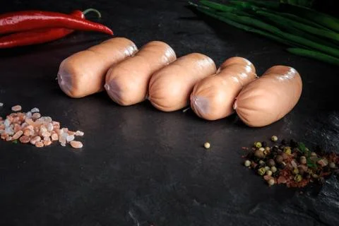 Small row of five short thick sausages with chili and onion Foto stock