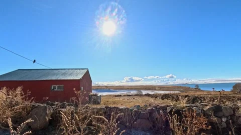 Small Rural House by Lake Under Bright Sun and Blue Sky Stock-Footage 330940865