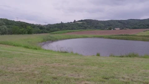 Small Rural Pond Surrounded By Green Fields And Hills In Lyon France Stock Footage 339050724