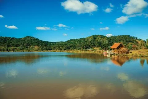 Small rustic shack reflected on the lakeside Stock Photos