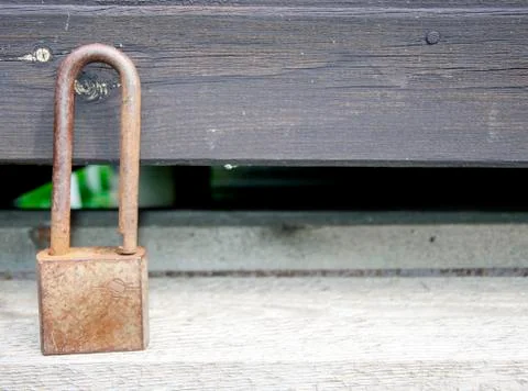 Small rusty lock standing on a moss-covered wood. Close up macro. 写真素材