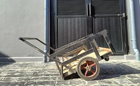 Small rusty old black cargo cart. midday sunlight 스톡 사진
