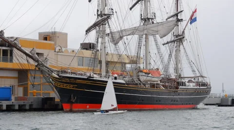 Small sail boat passing close to Stad Amsterdam Stock Footage 61326779
